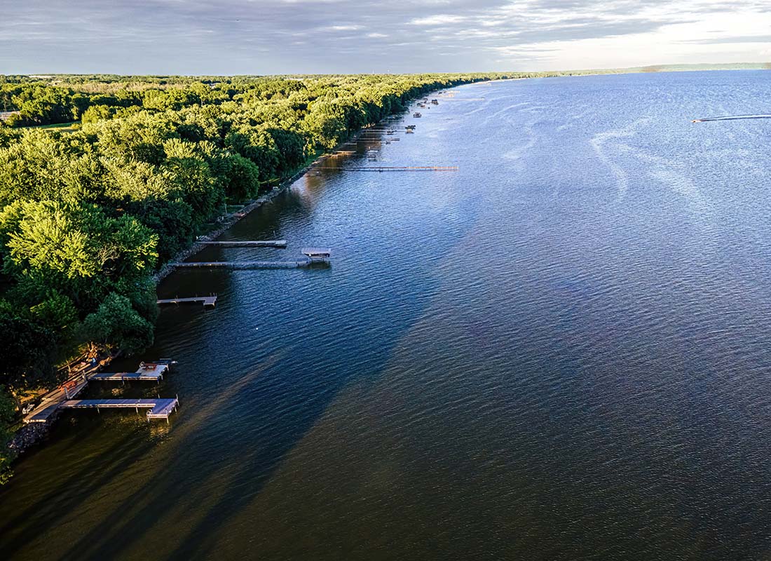 Stockbridge, WI - Aerial View of a Large Lake with Waterfront Homes Surrounded by Green Trees with Docks on the Water in Stockbridge Wisconsin